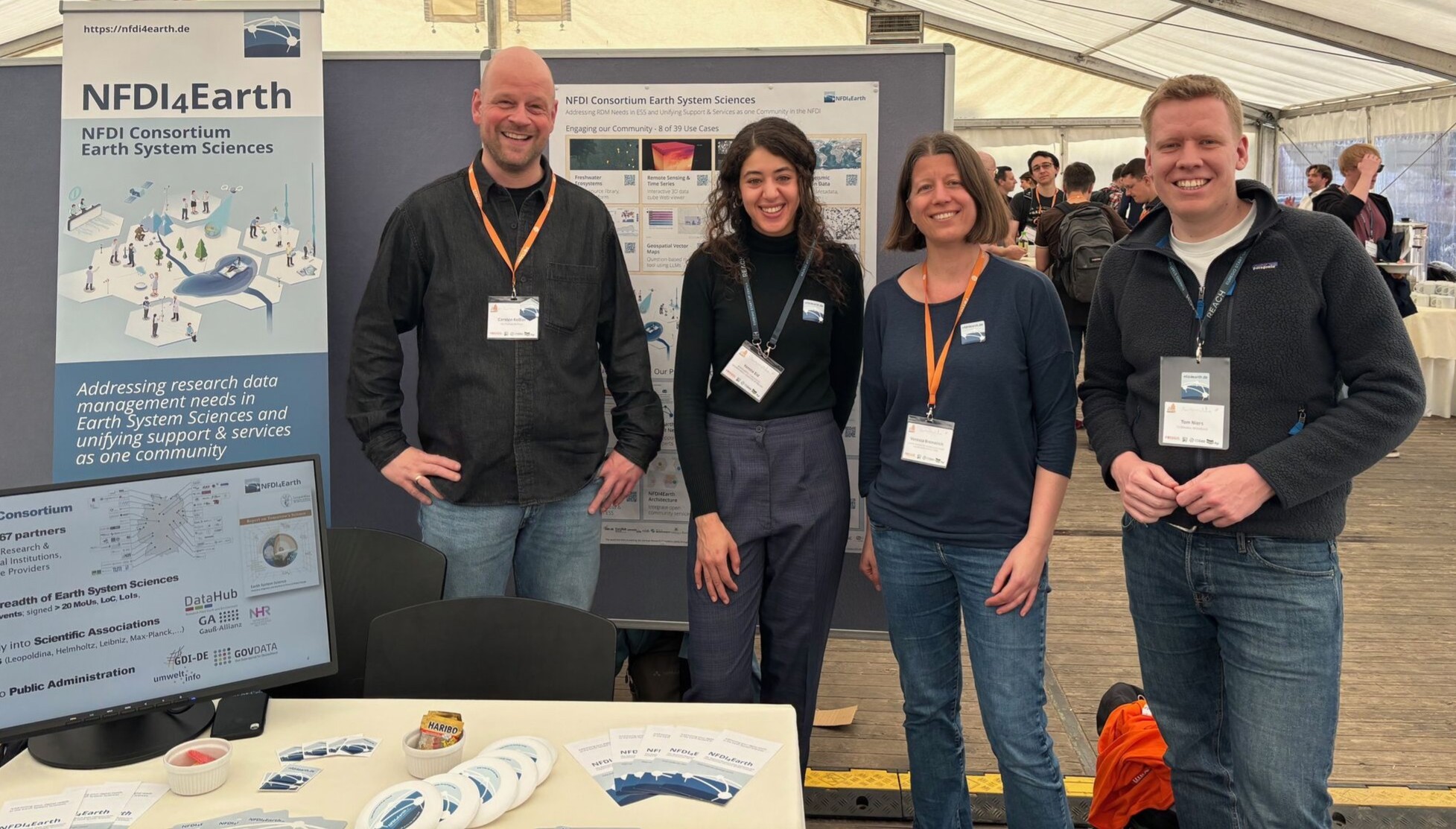 Picture of four NFDI4Earth team members at the NFDI4Earth booth at FOSSGIS 2025